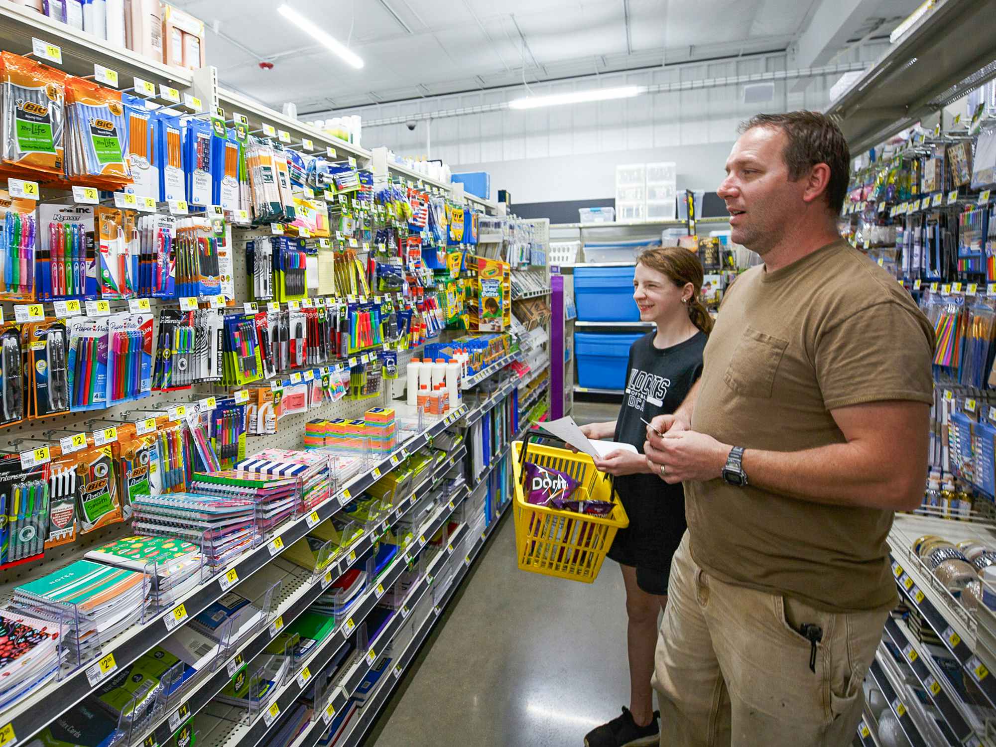 A parent and child shopping for school supplies at Dollar General