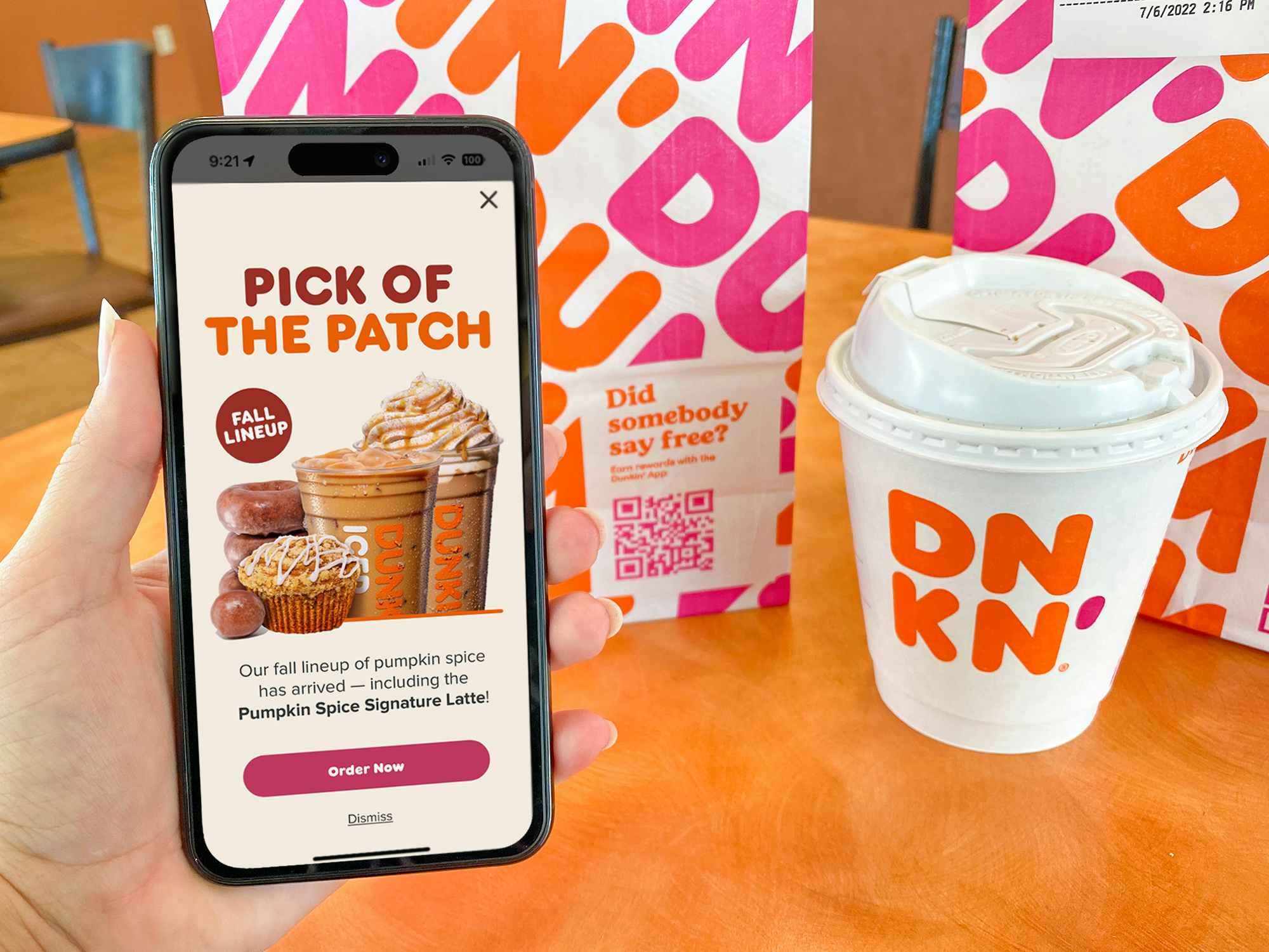 someone holding a phone displaying a Dunkin ad for the new Pumpkin Spice menu