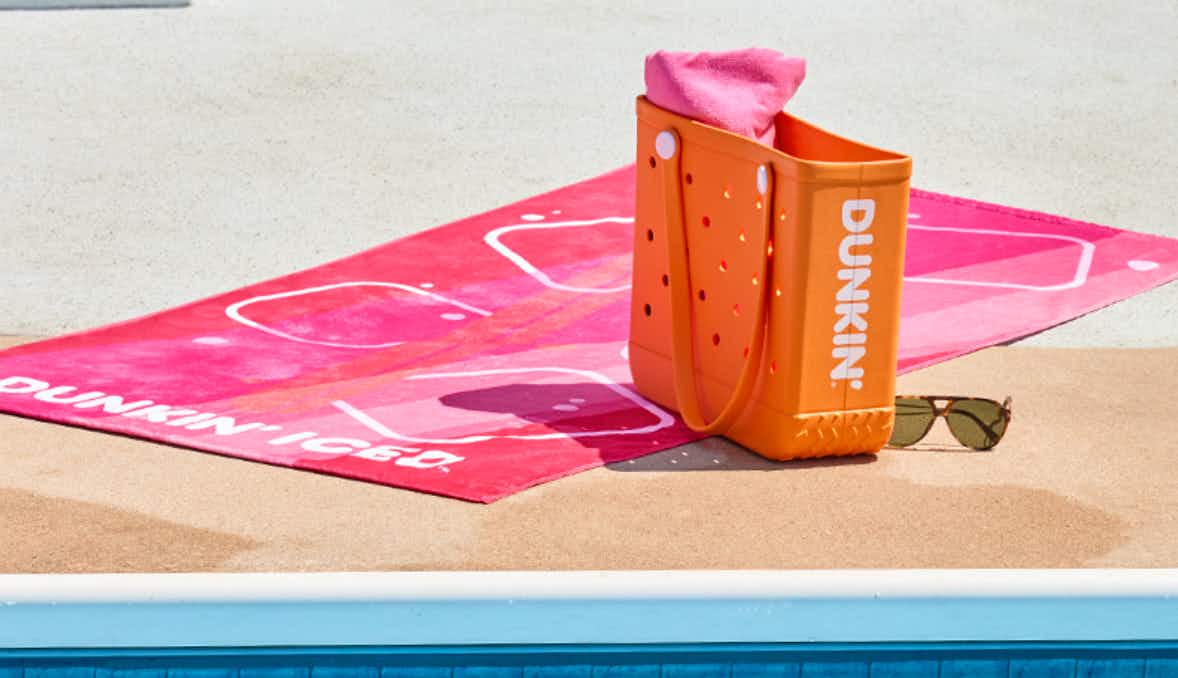 dunkin towel set next to a pool with a dunkin tote and sunglasses. 