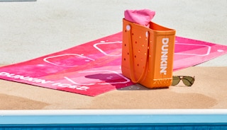 dunkin towel set next to a pool with a dunkin tote and sunglasses.