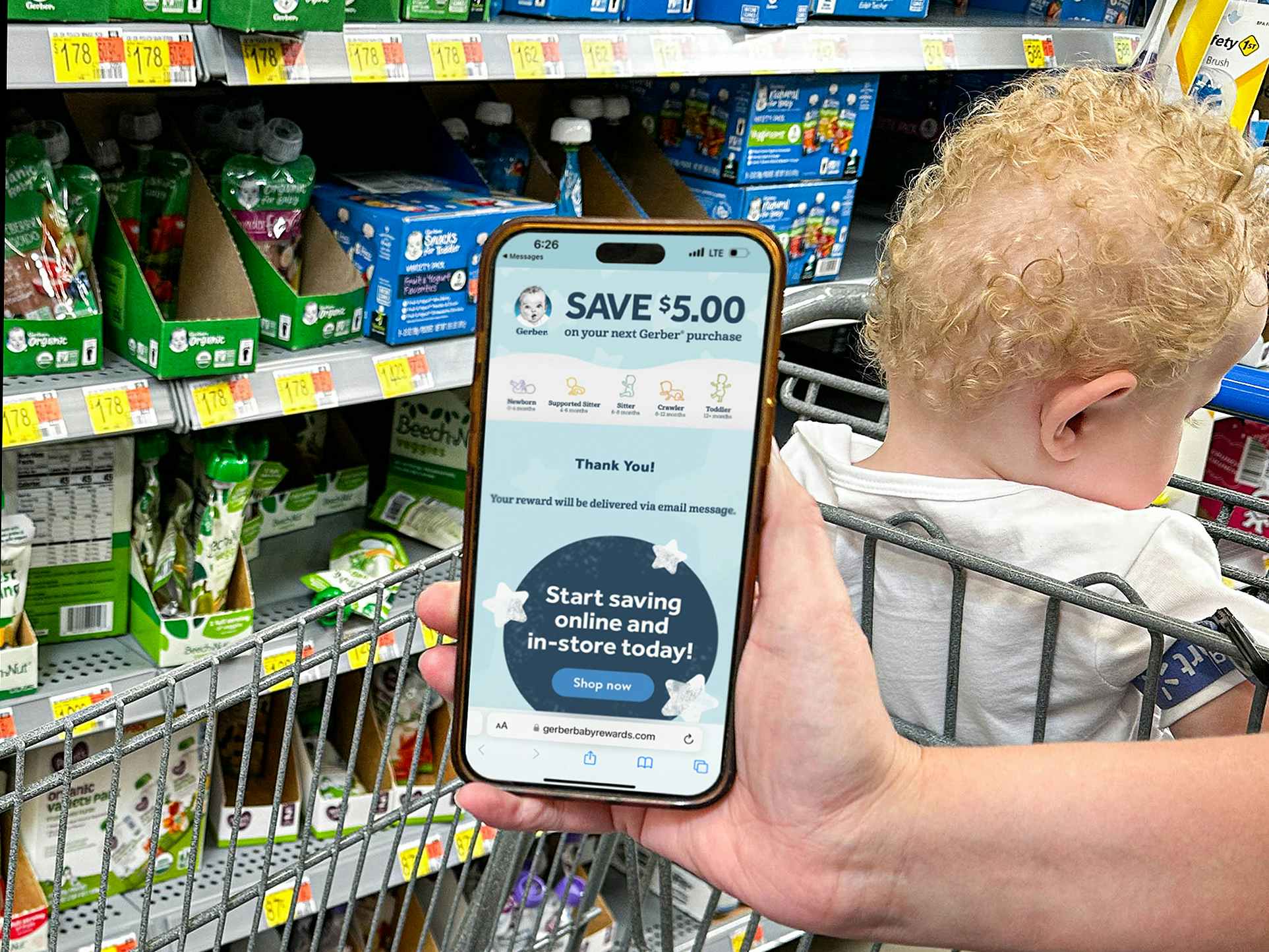a person holding gerber baby food and holding a phone with gerber rewards on screen
