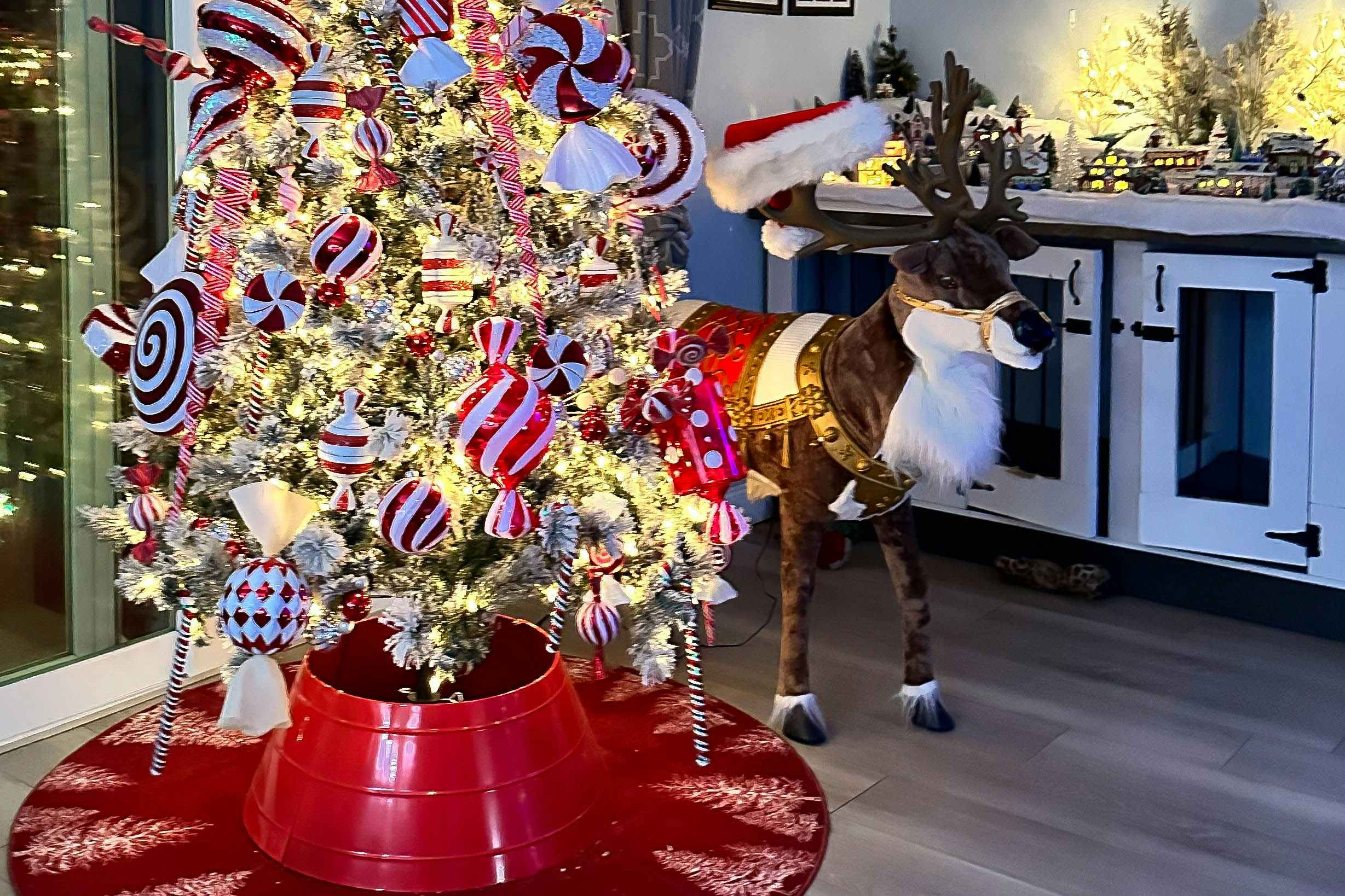 reindeer decor next to a lit christmas tree 