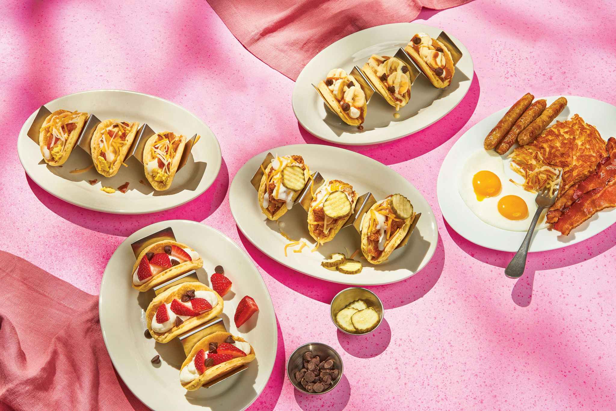ihop pancake tacos next to a combo of eggs, bacon, and hashbrown on a pink background