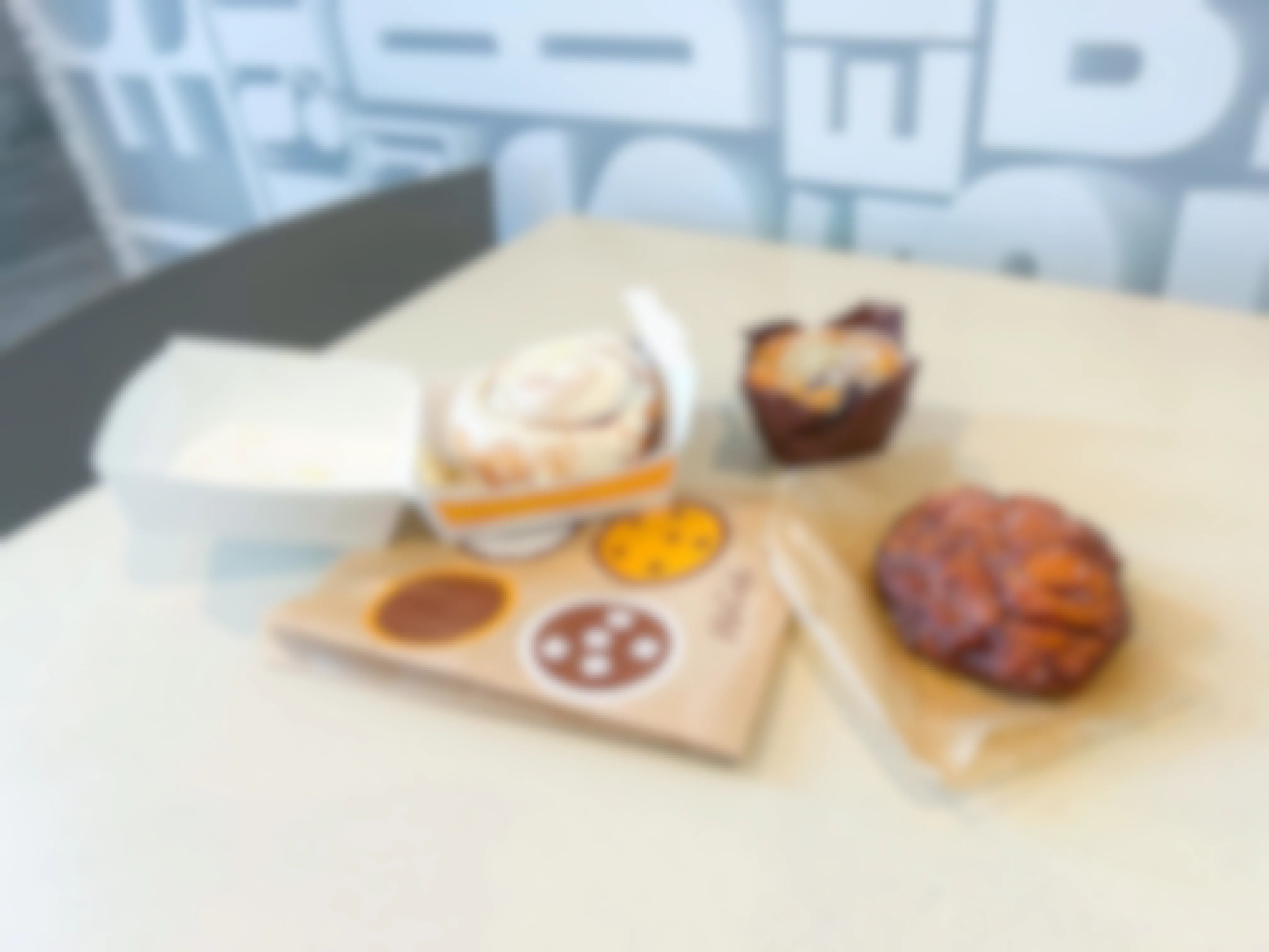 Mcdonalds bakery items, cinnamon roll with icing, blueberry muffin and an apple fritter