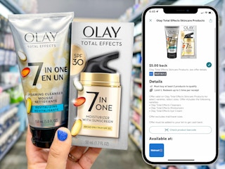 hand holding olay total effects skincare products and screenshot of ibotta deal on phone