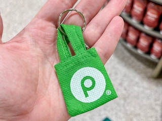 a person holding up a mini reusable bag keychain