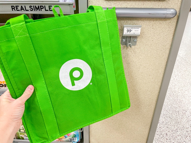 a hand holding up a publix reusable bag 
