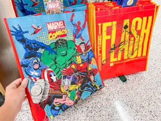 a person holding up a publix reusabe bag