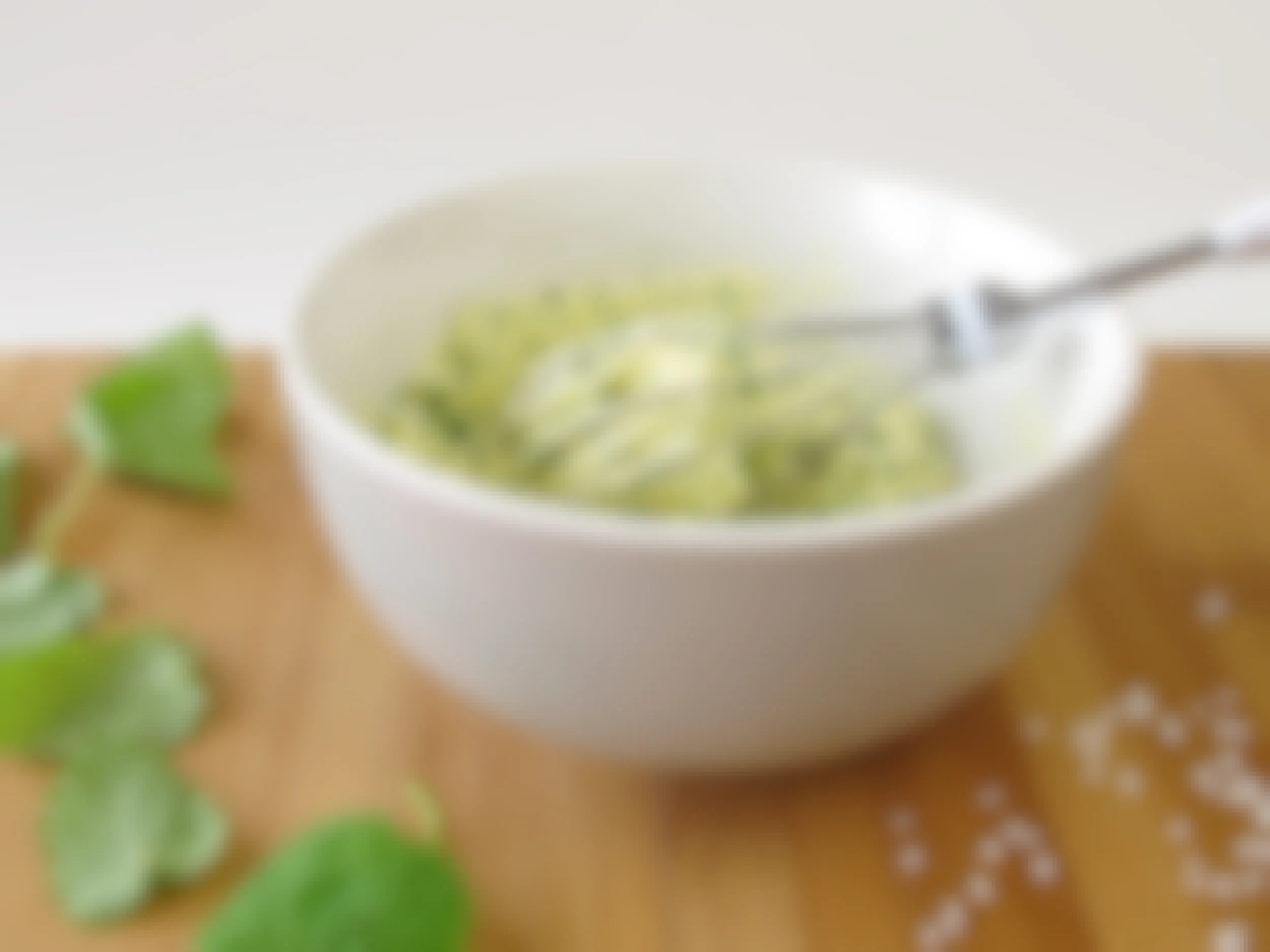 bowl of compound butter with whisk, herbs, and salt