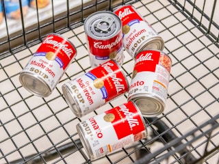 Assorted cans of Campbells brand soup in a cart