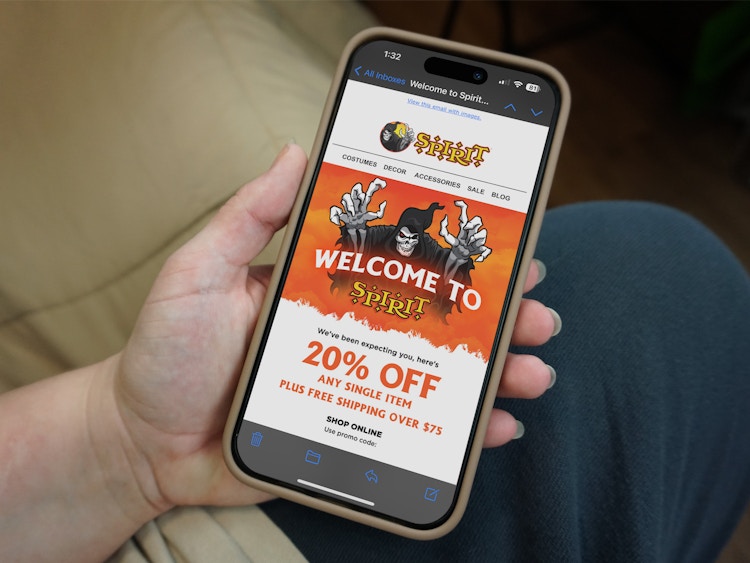 Someone reading the Spirit Halloween welcome email with a coupon for 20% off