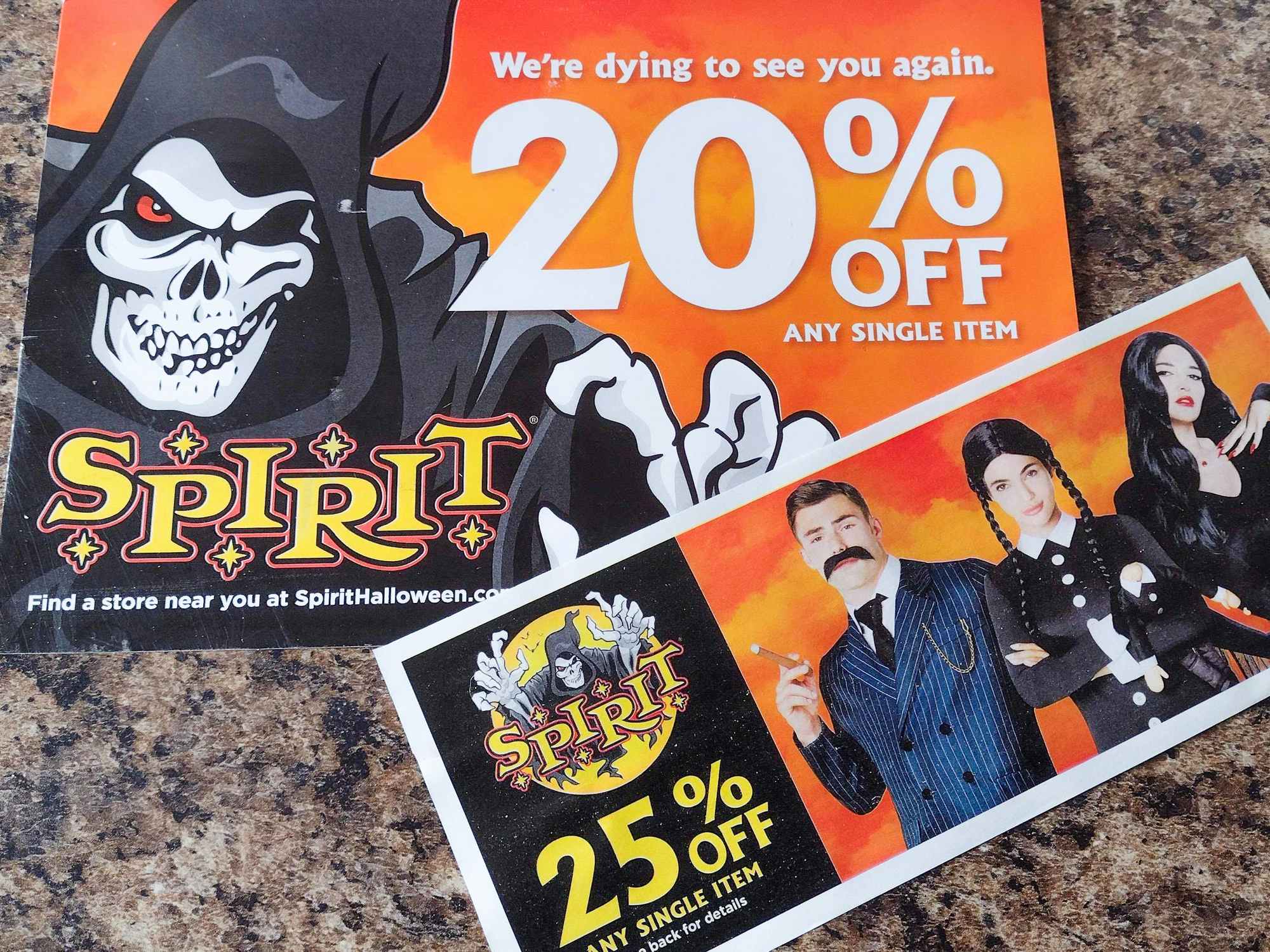 two spirit halloween paper coupons on counter top