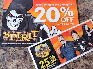 two spirit halloween paper coupons on counter top