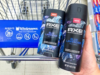 person holding axe fine fragrance collection near walgreens shopping cart