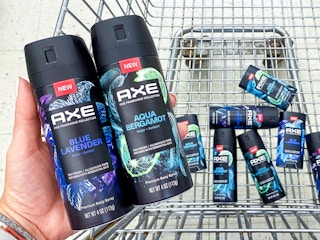 person holding axe fine fragrance collection near walgreens shopping cart