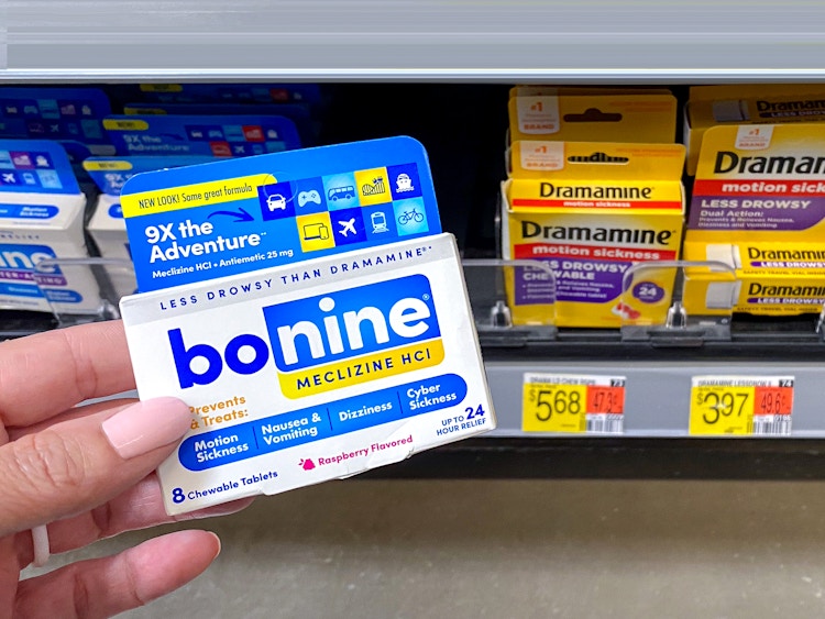 person holding person holding bonine meclizine near dramamine for comparison in walmart store