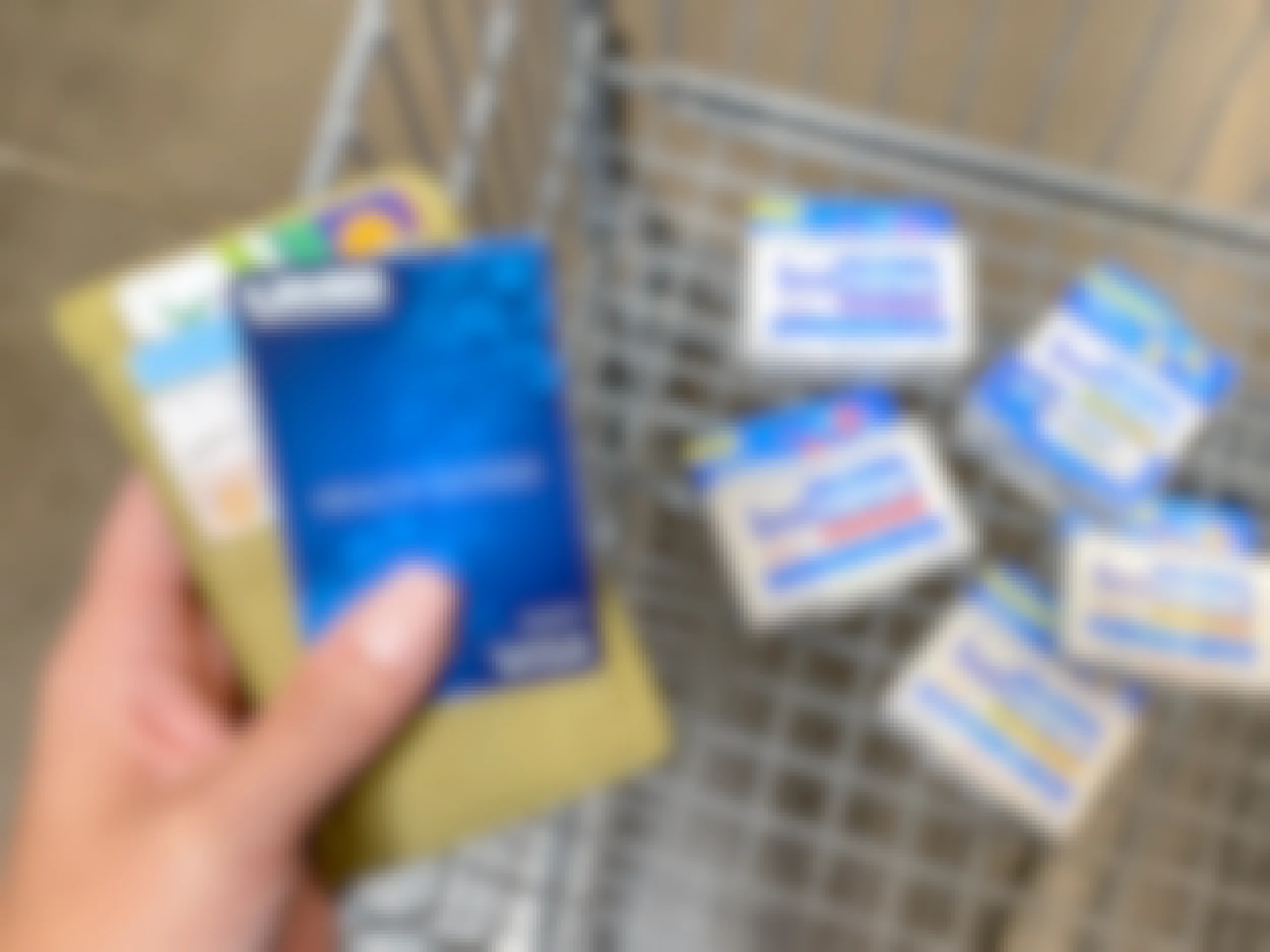 person holding wallet and hsa debit card with bonine meclizine products in walmart shopping cart