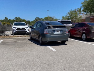 A car parked poorly in a parking lot