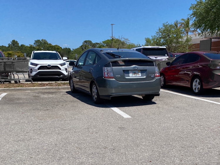 A car parked poorly in a parking lot