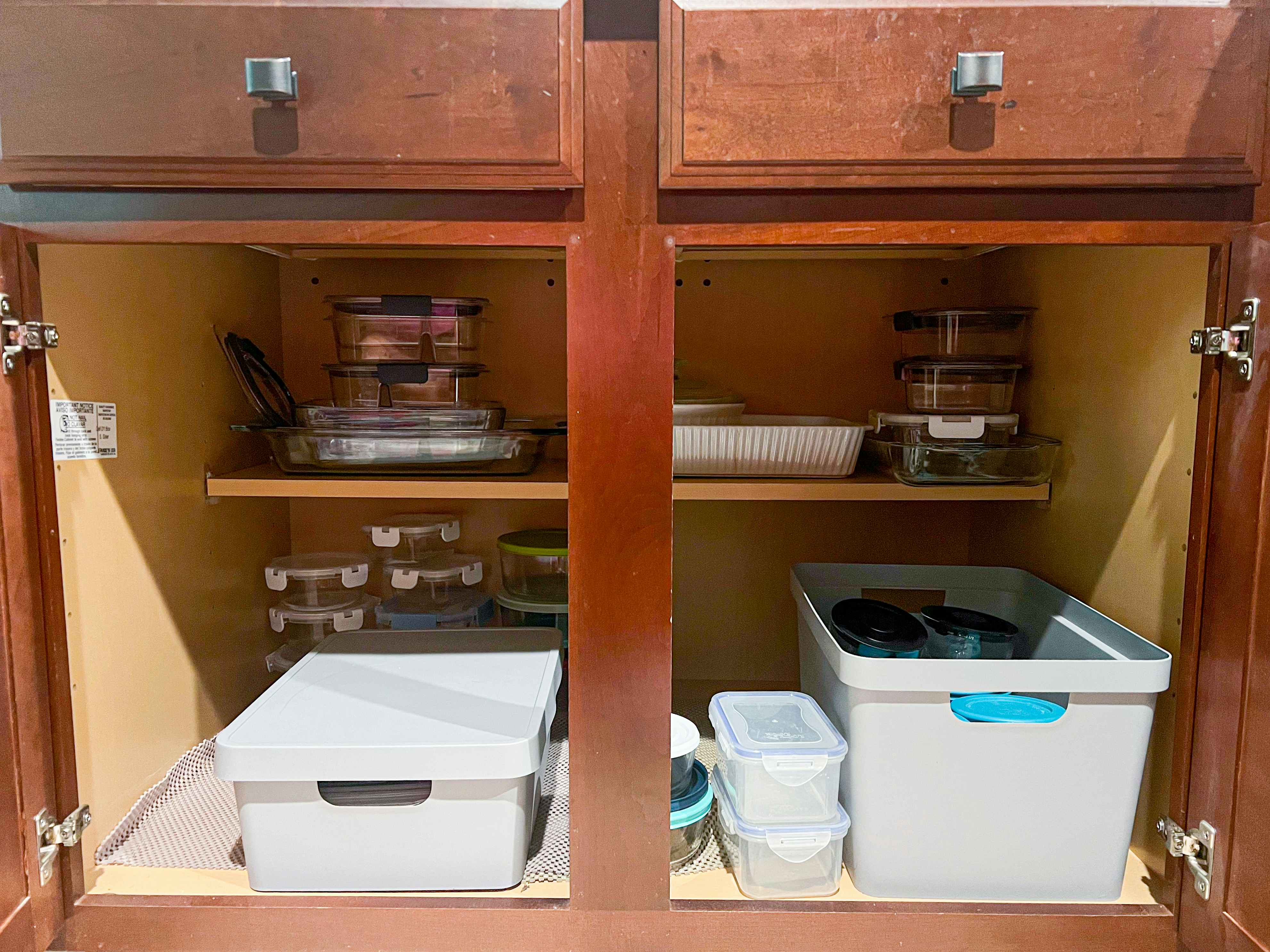 inside a tupperware cabinet with stacks of containers a 2 boxes