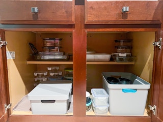 inside a tupperware cabinet with stacks of containers a 2 boxes