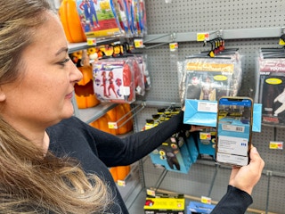 a person scanning a costume with walmart app in store