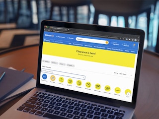A laptop displaying the clearance section page on the Walmart website with the search results for "halloween costumes