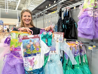 a person holding up disney costumes in walmart