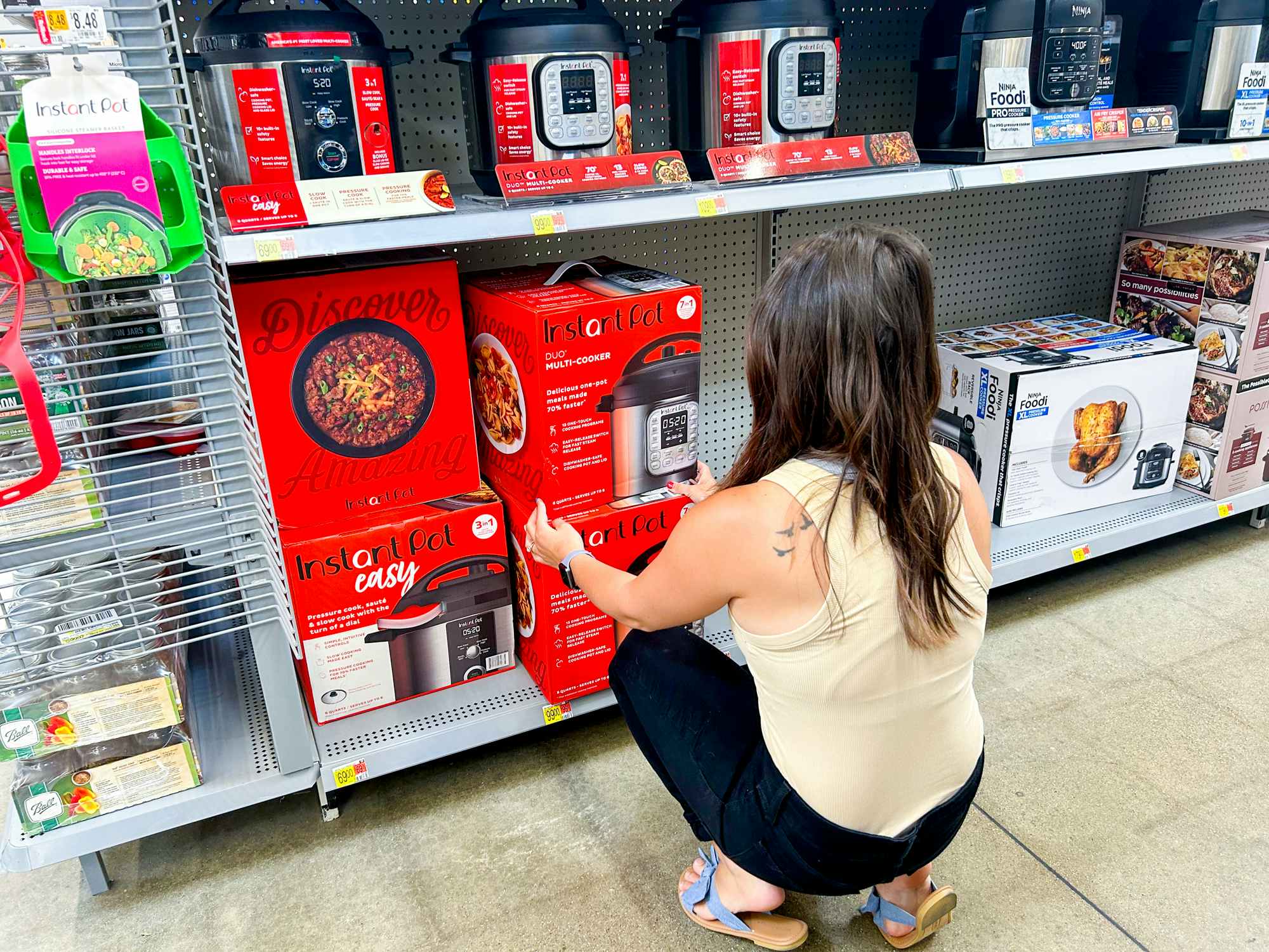 a person reaching for an instant pot in walmart