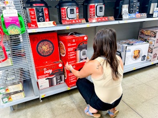 a person reaching for an instant pot in walmart