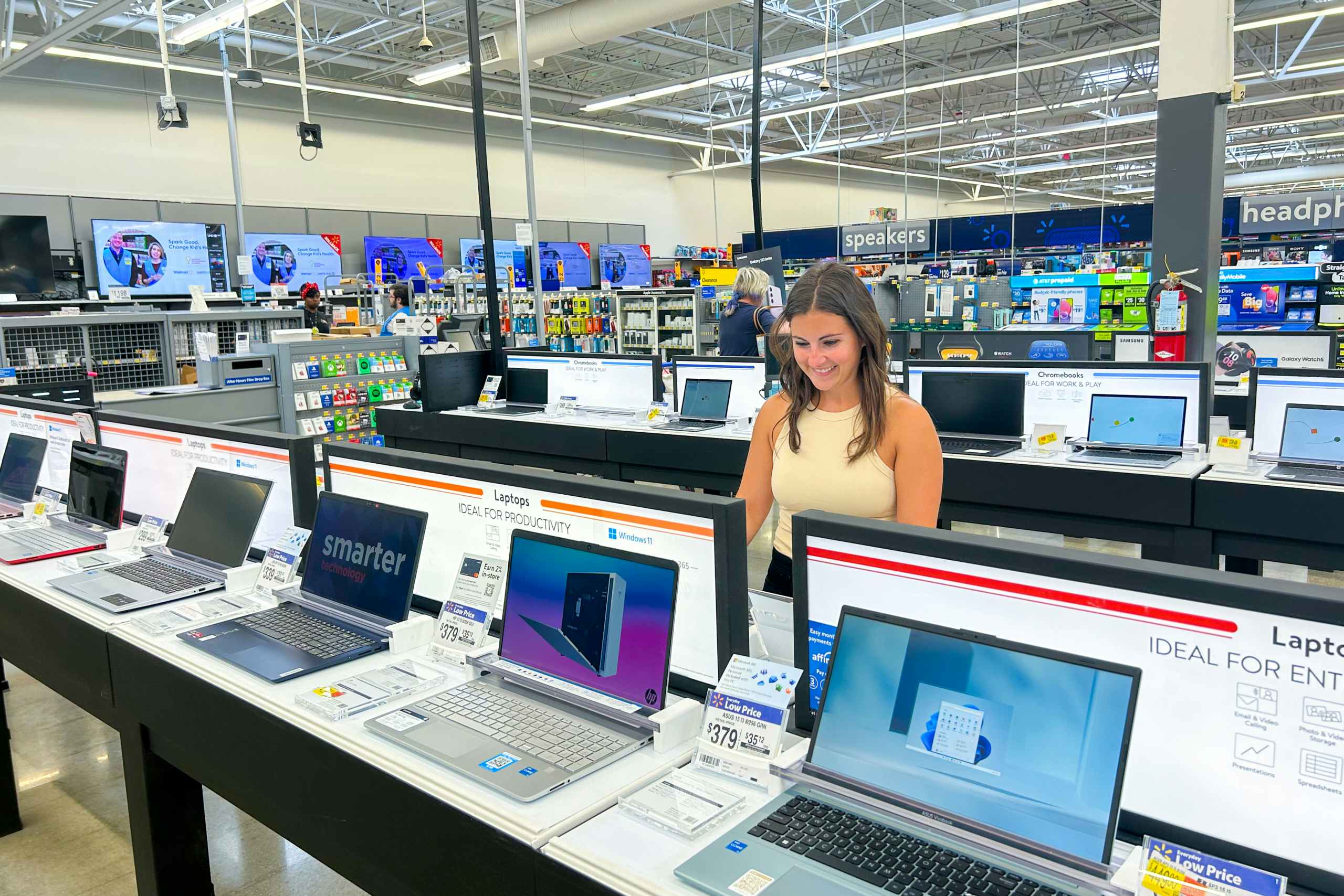 a person looking at laptops in walmart smiling