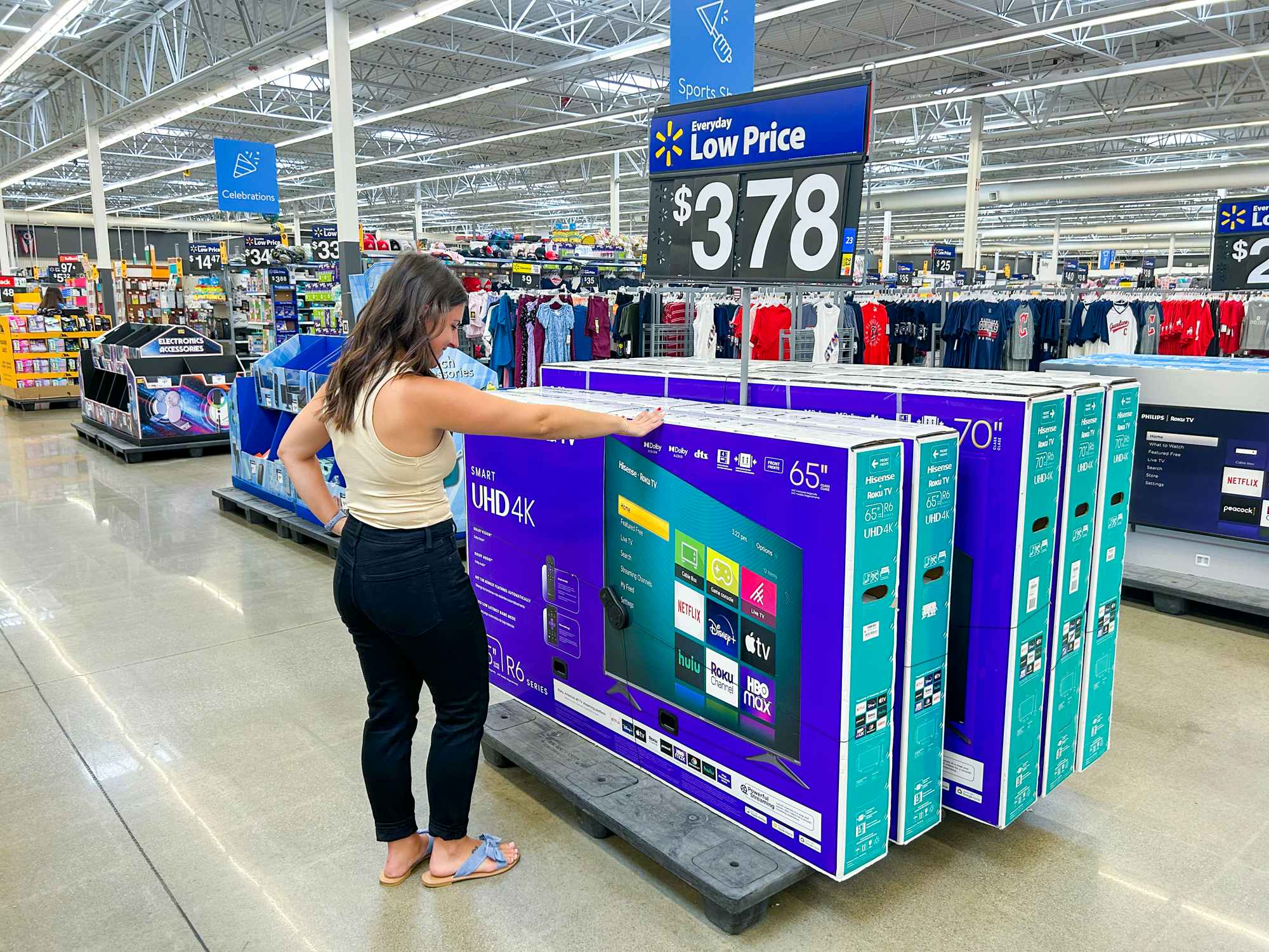 a person looking at TVs in walmart