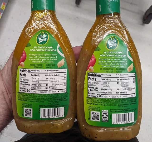 person holding two bottles of wish bone salad dressing with different ingredients