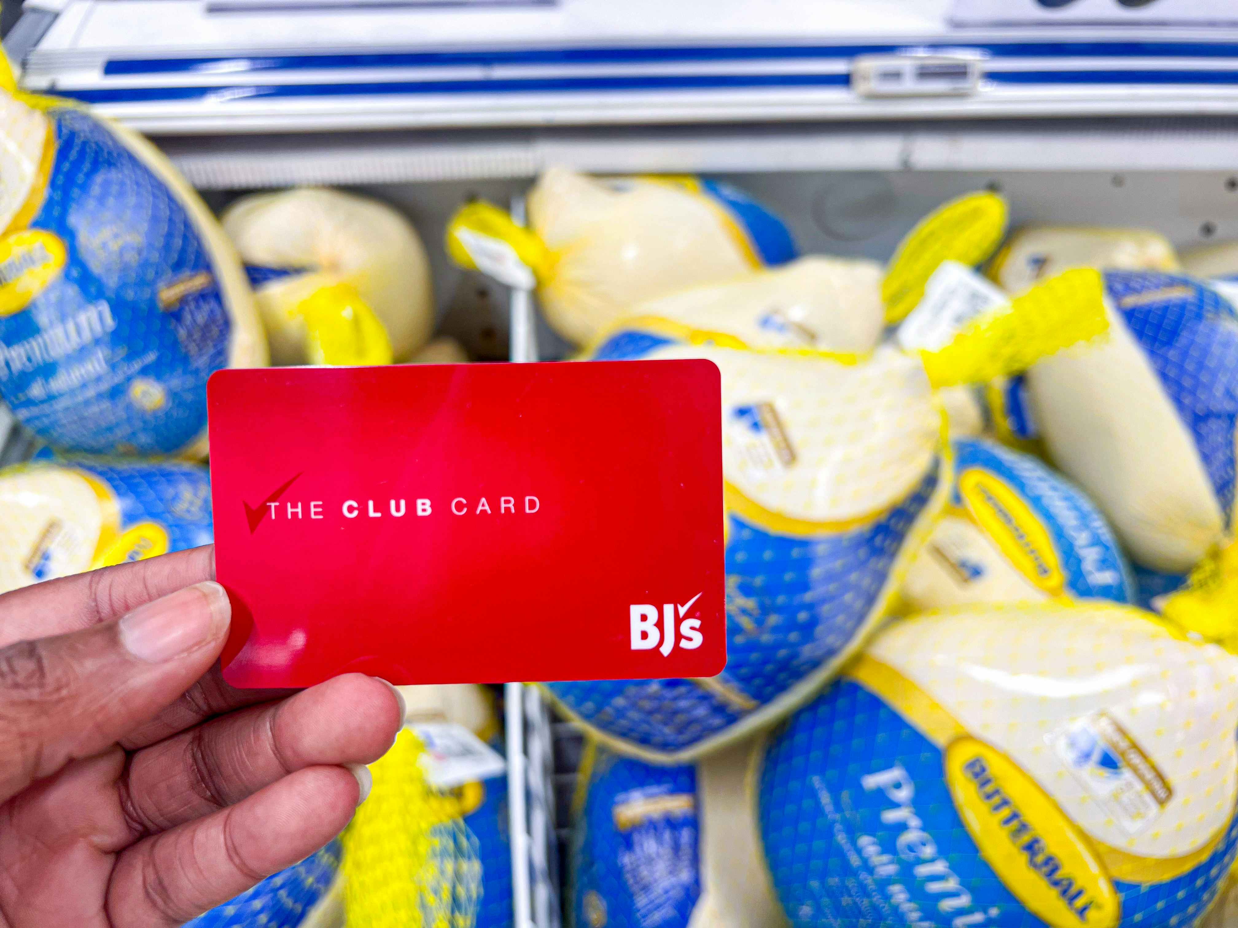 Hand holding a red Bj's Membership card
