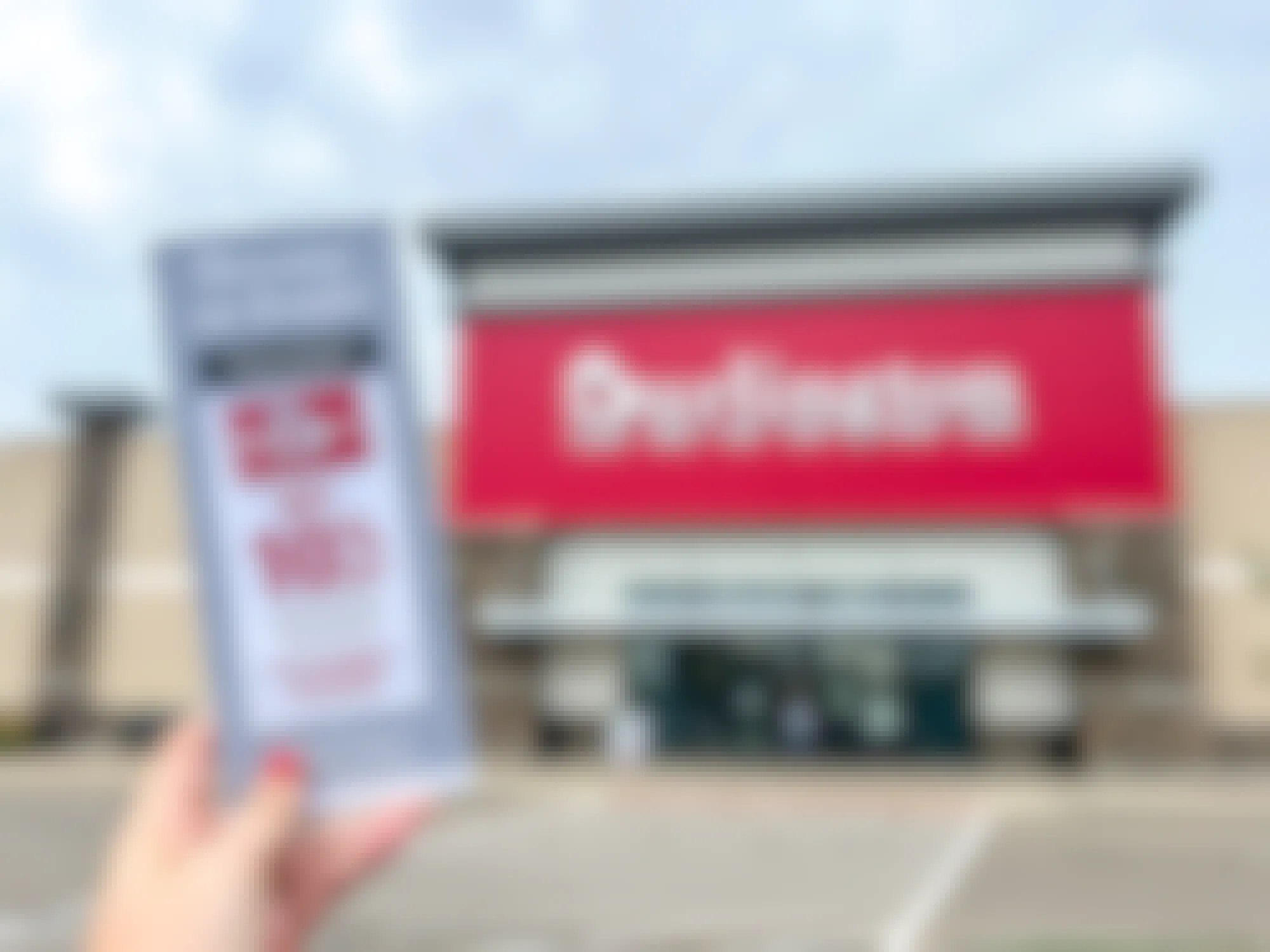a person holding up a burlington credit card pamphlet in front of a burlington store 