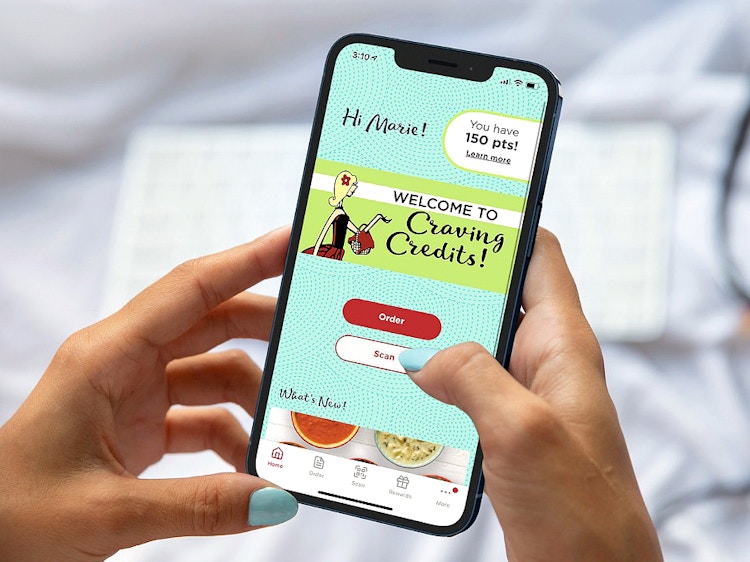 person holding a phone and looking at the chicken salad chick app