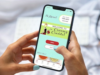 person holding a phone and looking at the chicken salad chick app