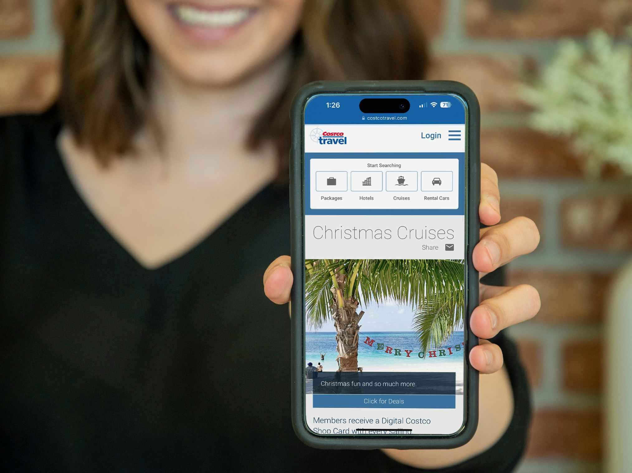 Someone holding up a phone displaying the Costco website's page about their Christmas cruises