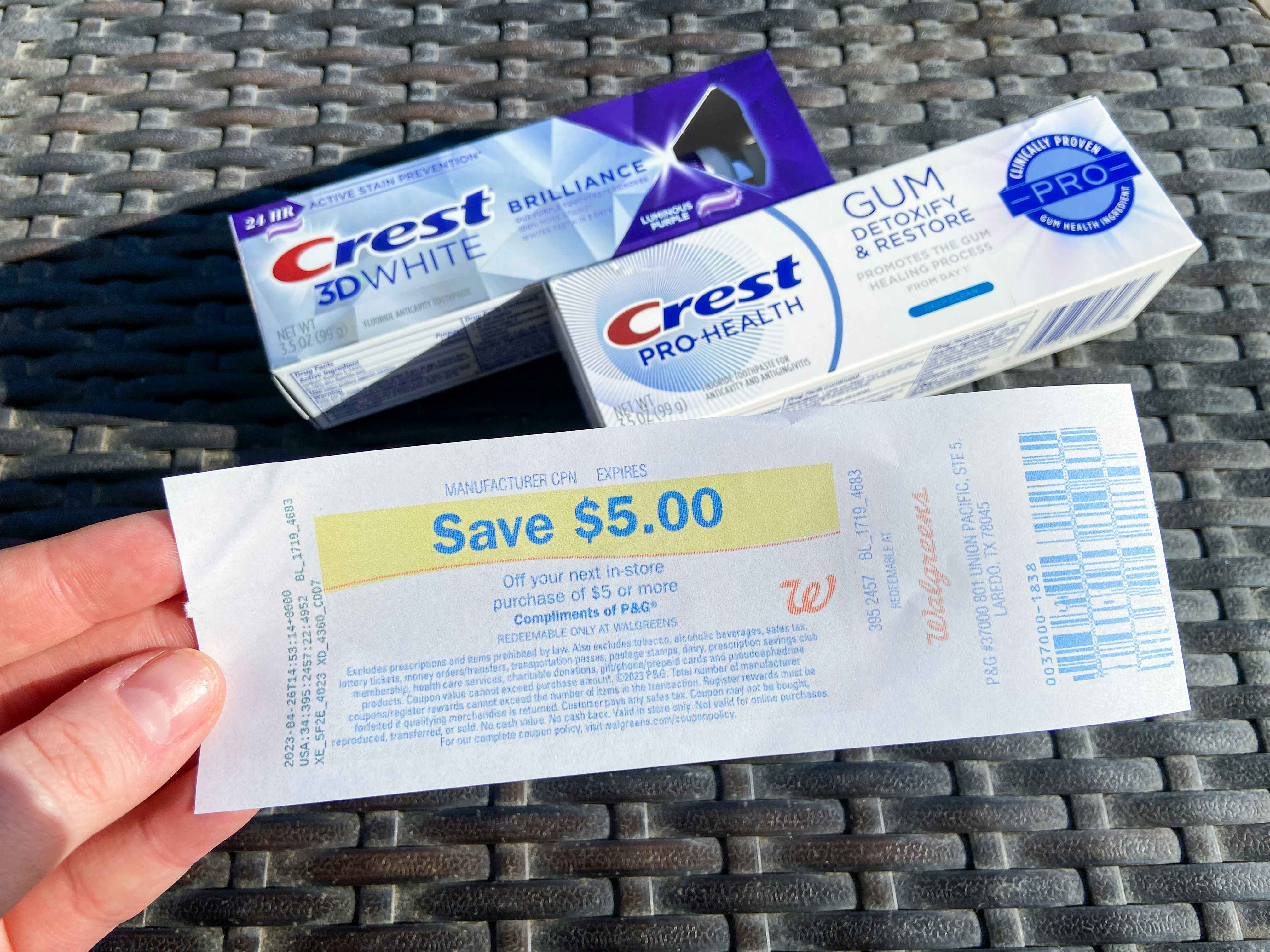 hand holding register reward with crest premium toothpaste in background