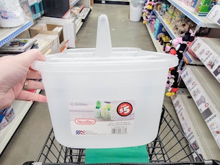 a person holding up a 5 dollar sterilite bath caddy