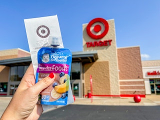 a person holding up gerber baby food with a receipt in front of the target sign