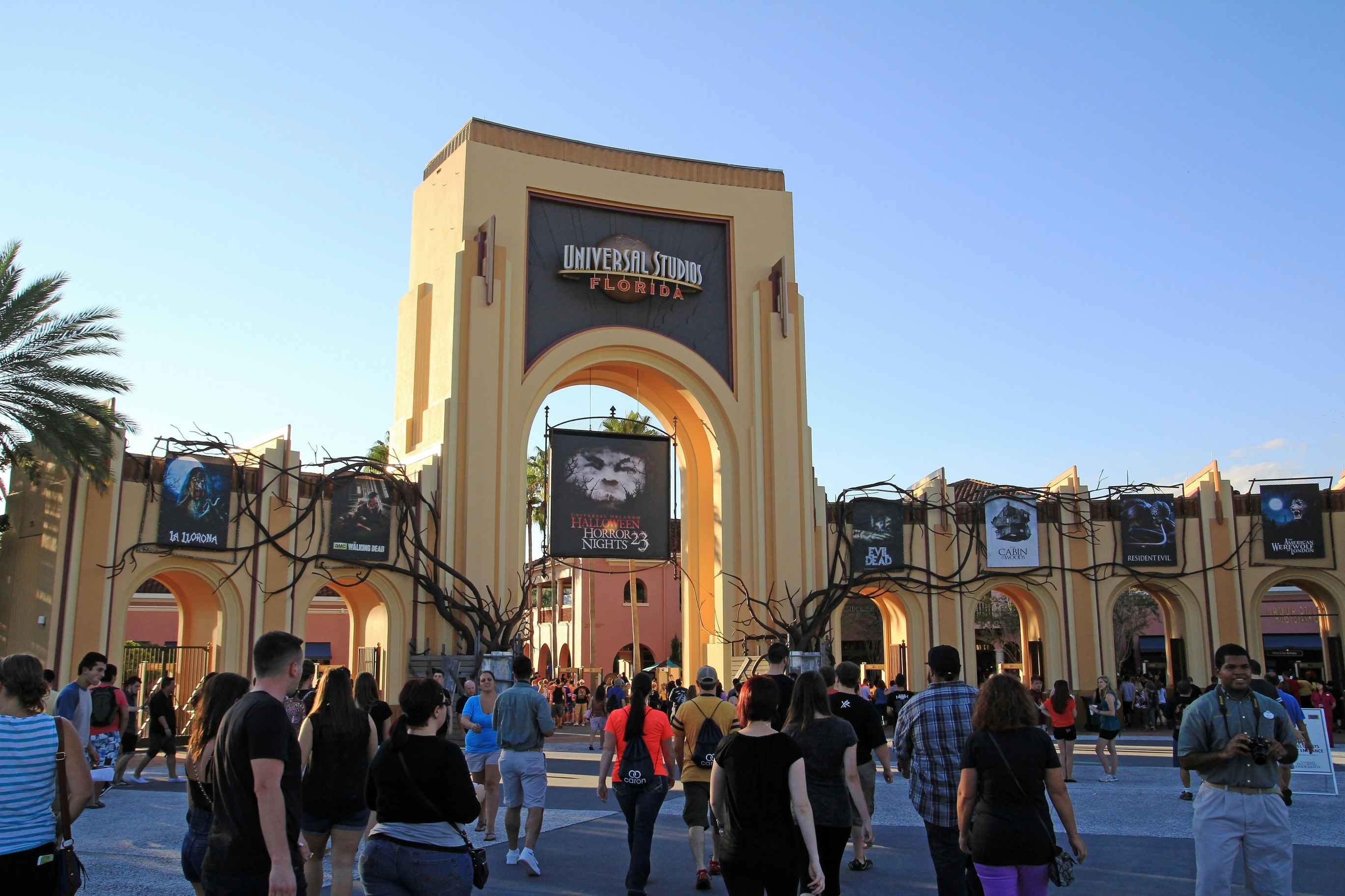 people walking near the entrance of Universal Studios above is a sign that says halloween horror nights