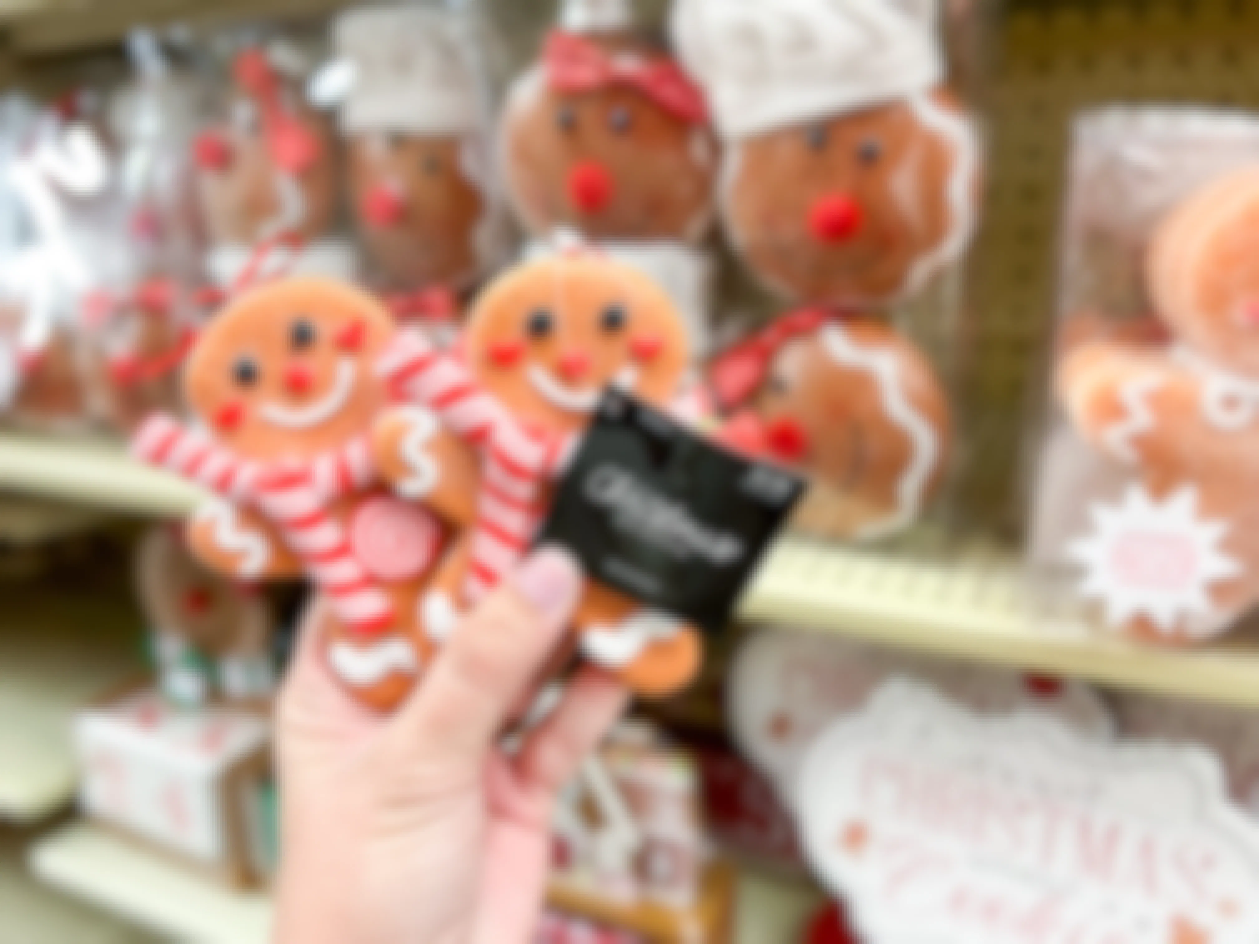 hand holding up gingerbread ornaments