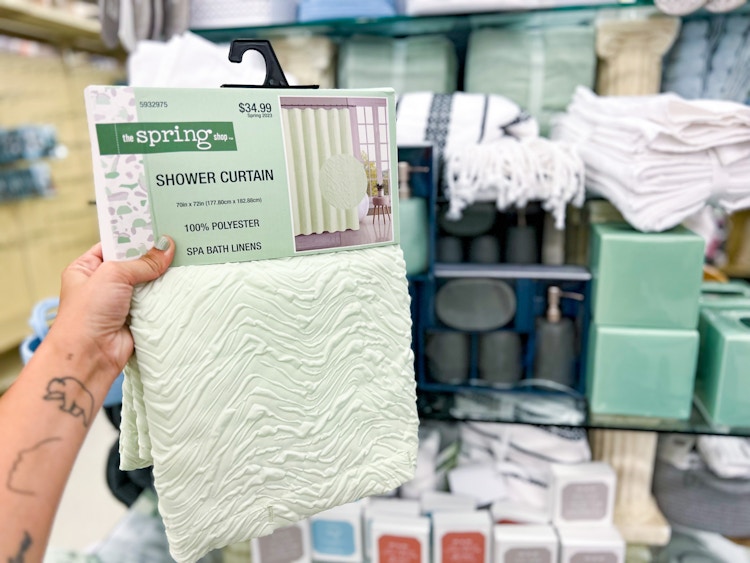 hand holding up a mint green shower curtain