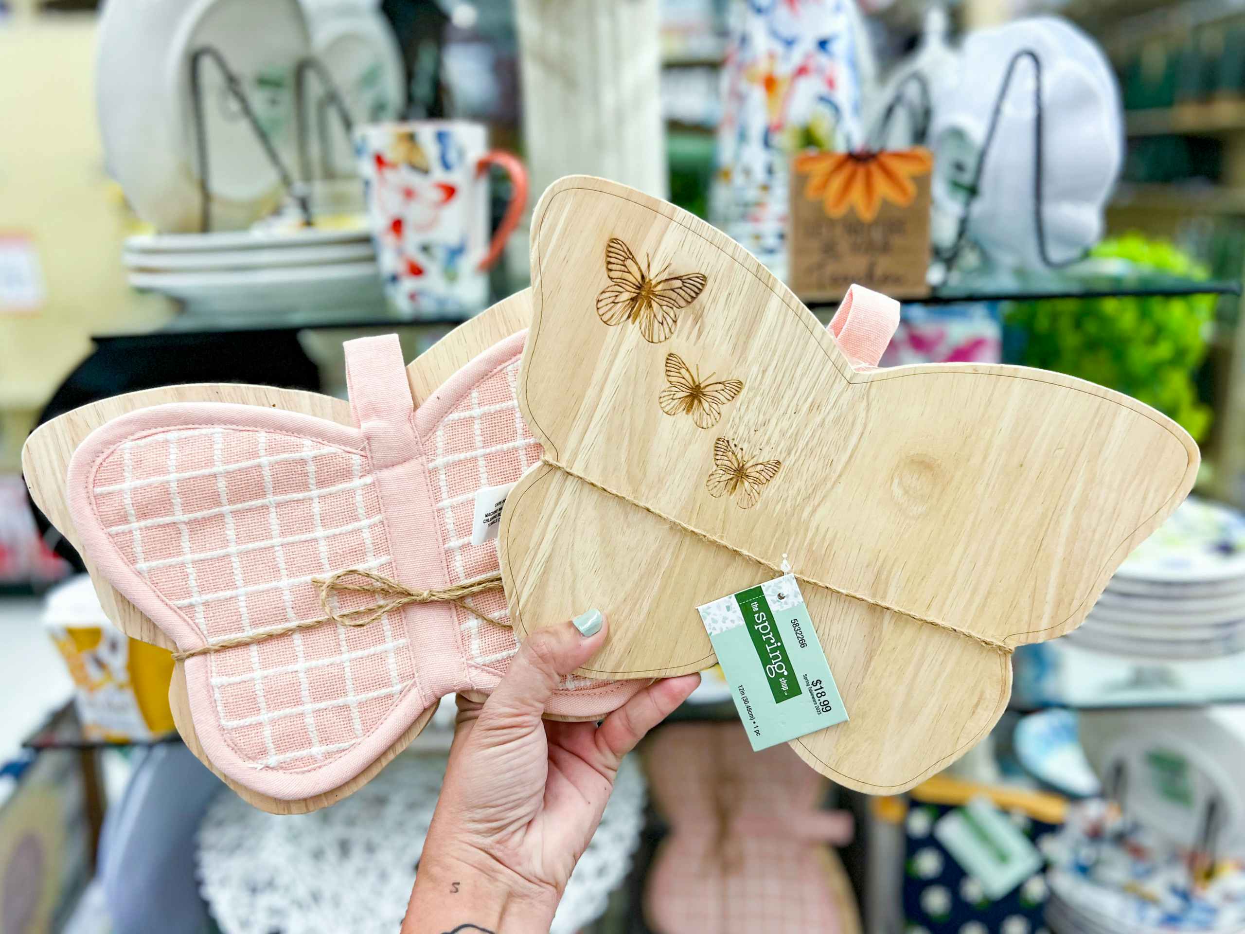 hand holding up a pink checkered butterfly shaped pot holder and matching wood cutout