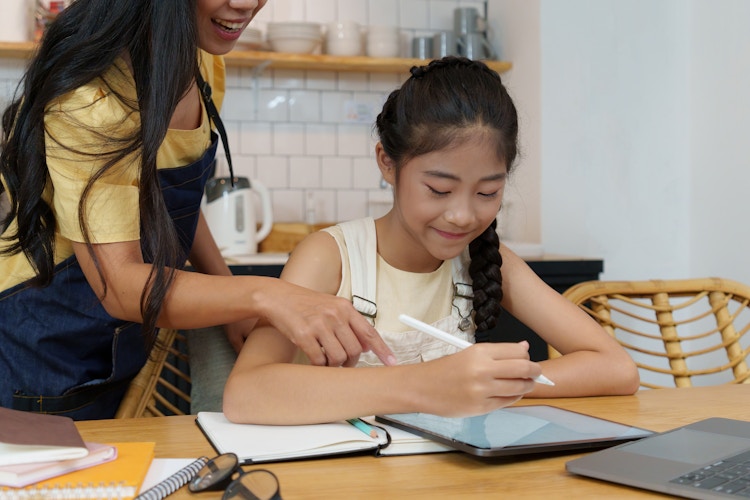 a homeschool student working on an assignment with direction from parent