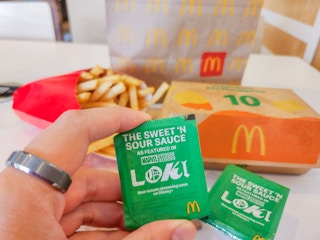 a person holding up the new loki sauce from mcdonalds
