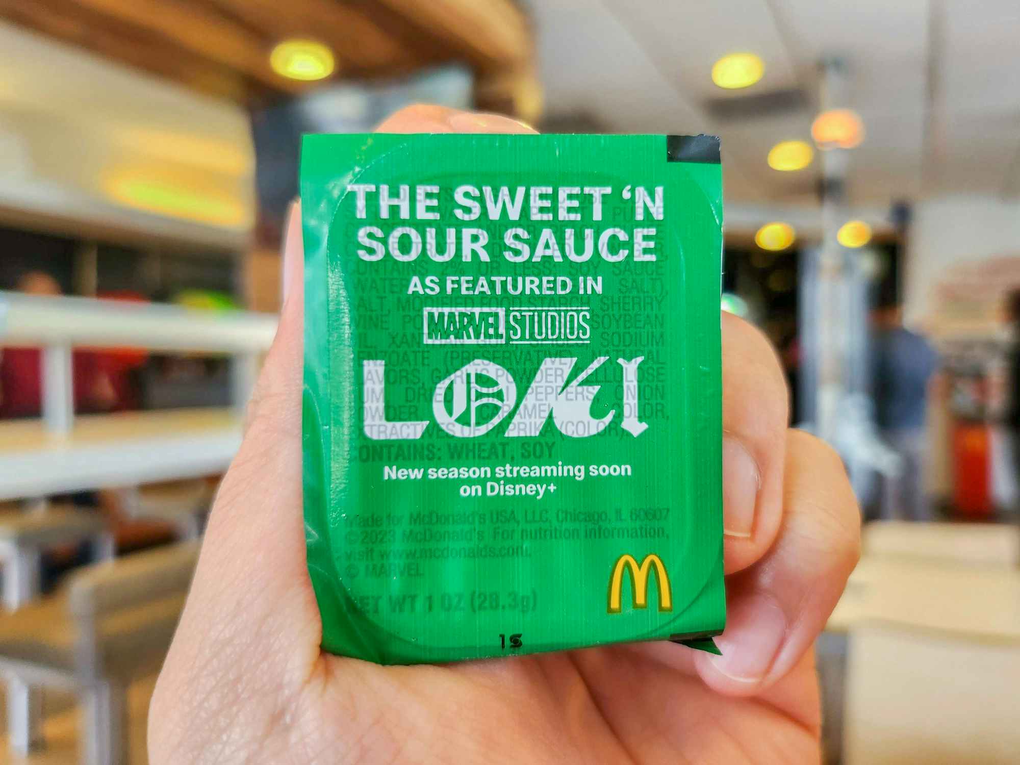 a person holding up the new loki sauce from mcdonalds