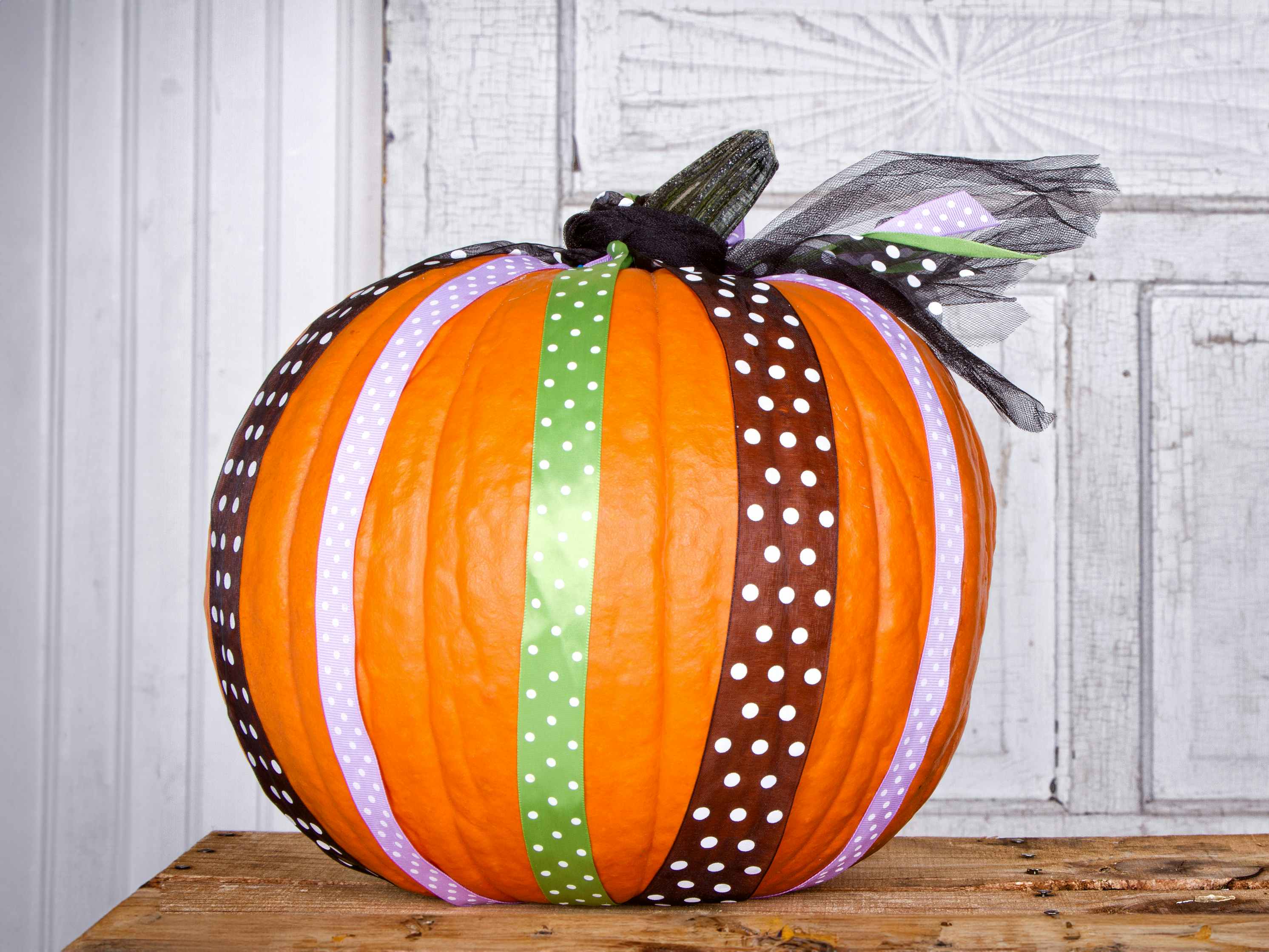 a pumpkin decorated with ribbons