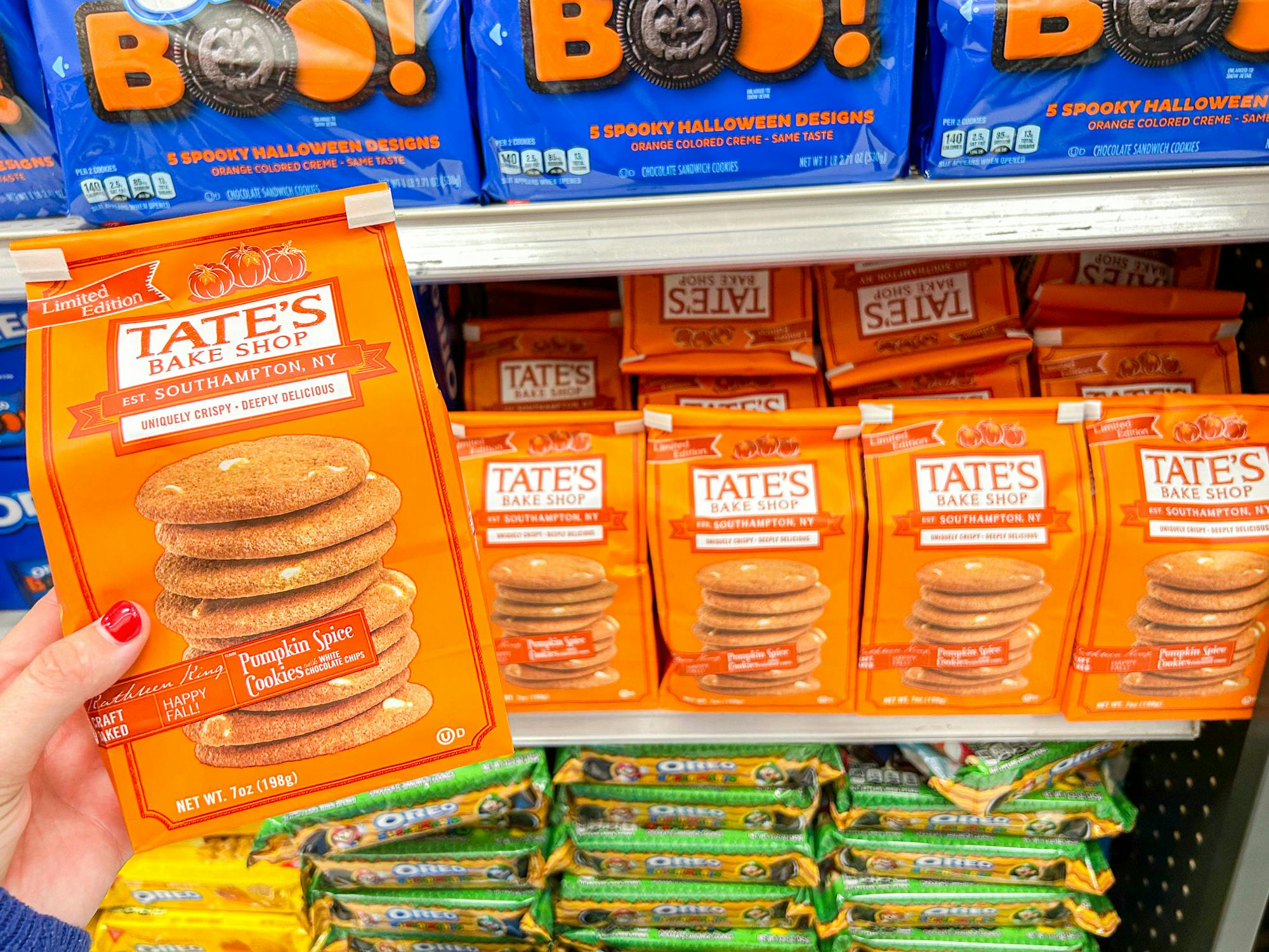 a person holding up tates pumpkin spice cookies in target